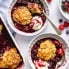 berry cobbler in two bowls with vanilla ice cream
