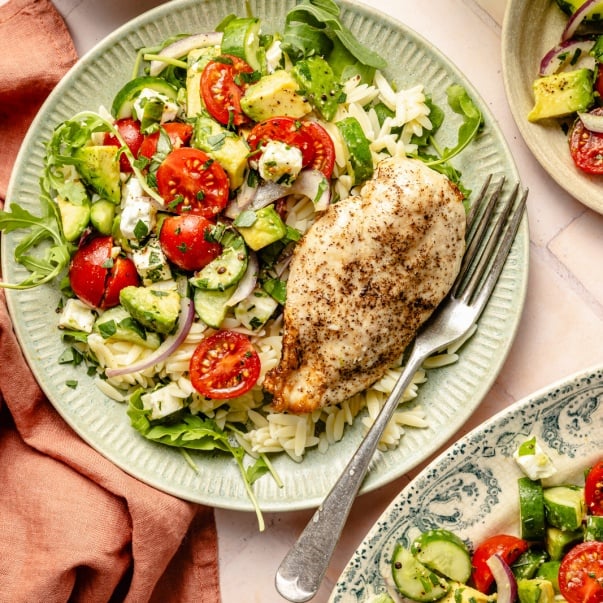 tomato cucumber salad on a plate with chicken