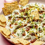 chili crisp cheese dip on a platter with crackers