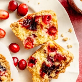 cranberry orange muffin split in half on a platter