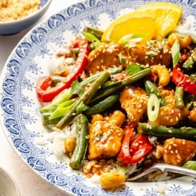 healthy orange chicken stir fry on a plate with rice