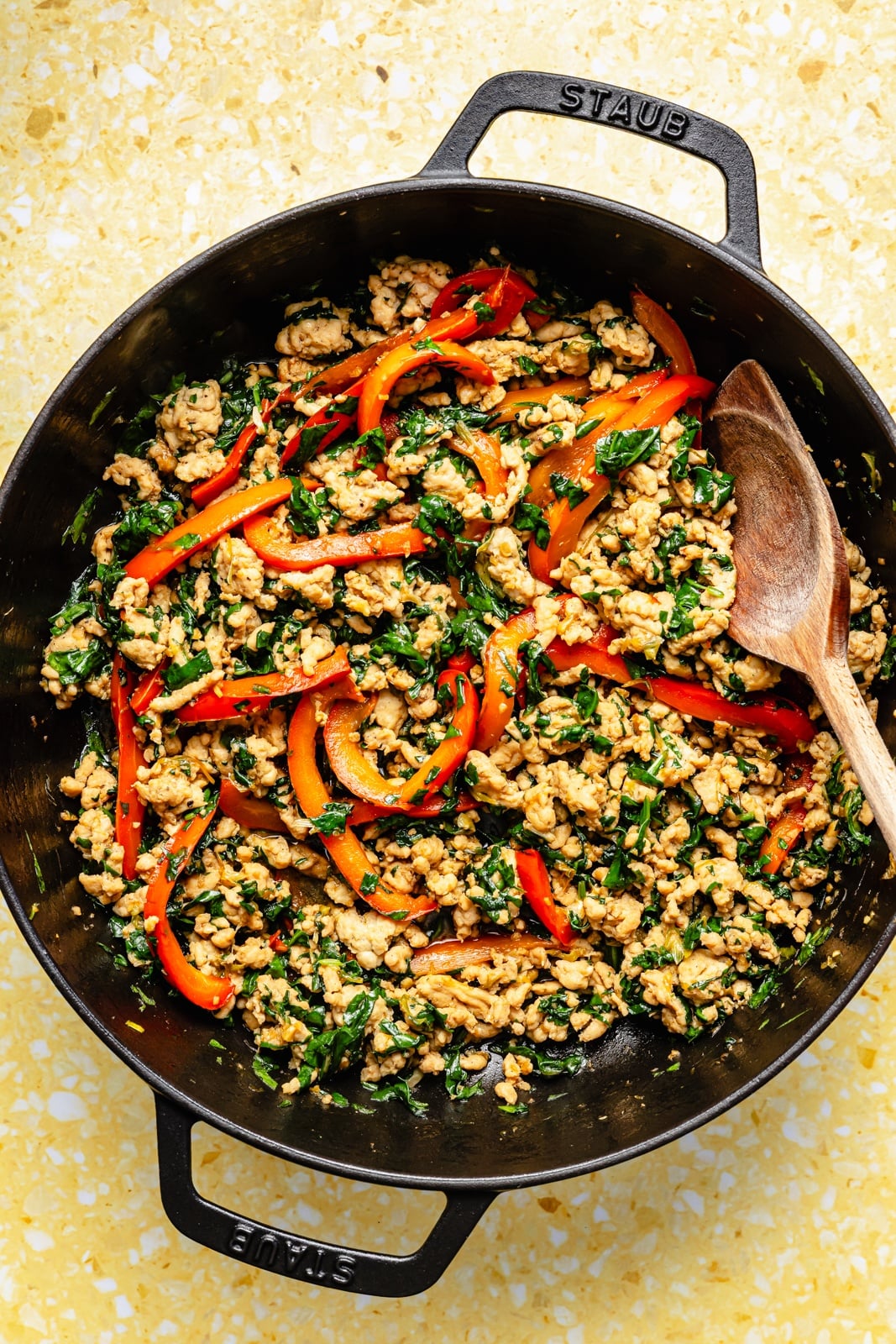 cooking chicken and vegetables in a pan to make peanut chicken noodles