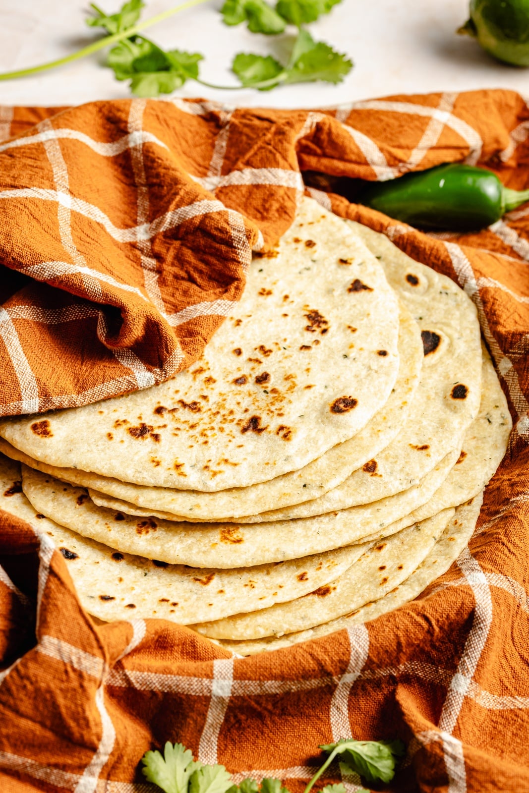 homemade tortillas wrapped in an orange towel