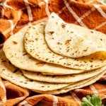 homemade flour tortillas on an orange towel
