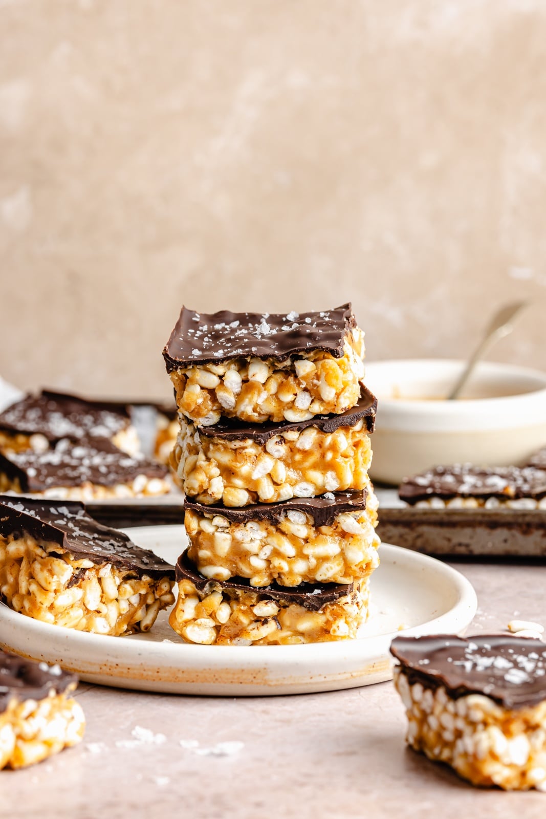 Healthy rice krispie treats made without marshmallows and with peanut butter, coconut oil, maple syrup, and brown rice krispies. These vegan and gluten-free peanut butter rice krispie treats are topped with dark chocolate and sea salt for an indulgent treat that tastes just like a crunchy peanut butter cup. Options to add a bit of protein powder to make these a great post-workout treat! healthy peanut butter rice krispie treats in a stack