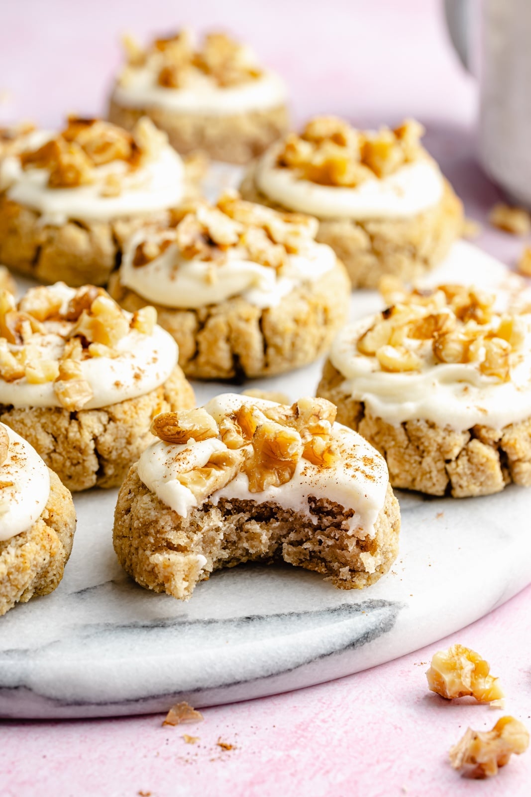 Soft, healthy banana cookies made with a mix of almond and coconut flour to make them gluten and grain-free! These banana bread cookies taste like a slice of your favorite banana bread and are topped with a luscious cream cheese frosting for a delicious treat everyone loves. healthy banana cookie with a bite taken out