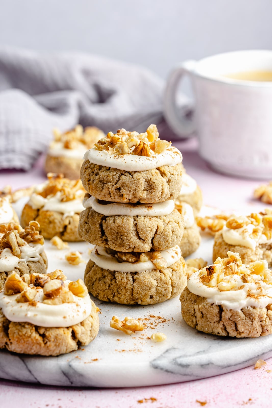 Soft, healthy banana cookies made with a mix of almond and coconut flour to make them gluten and grain-free! These banana bread cookies taste like a slice of your favorite banana bread and are topped with a luscious cream cheese frosting for a delicious treat everyone loves. healthy soft banana cookies in a stack