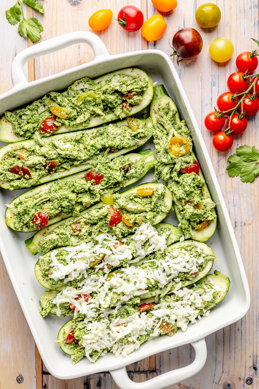 layering pesto chicken zucchini boats in a pan