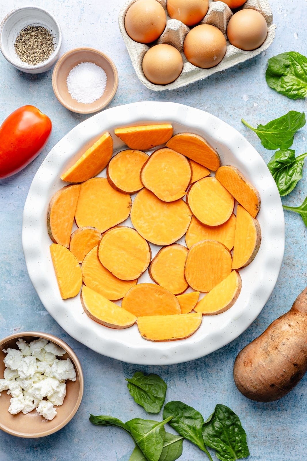 sweet potato slices arranged in a pan for a sweet potato crust quiche
