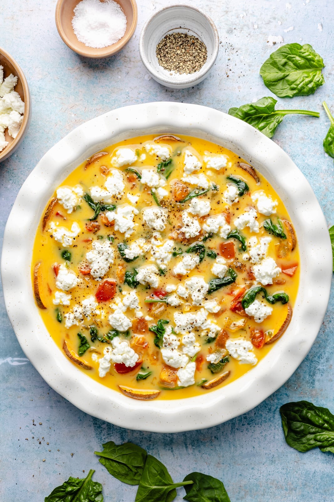 unbaked goat cheese quiche with a sweet potato crust in a pie pan