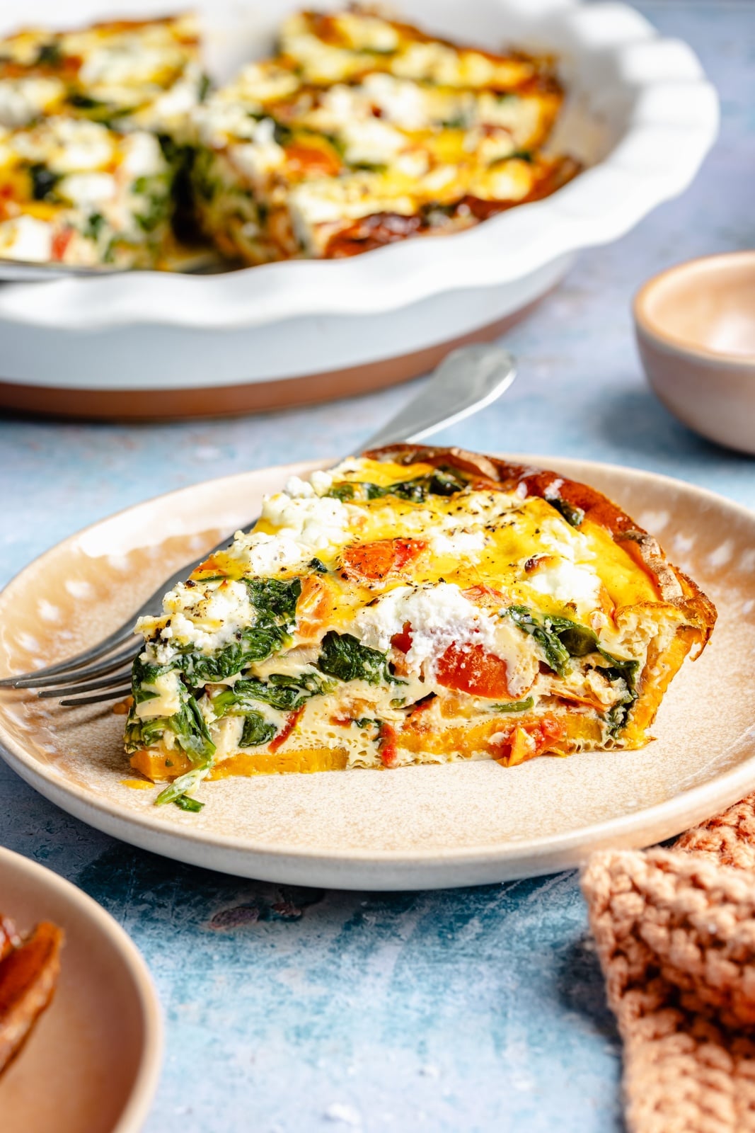 slice of spinach and goat cheese quiche on a plate