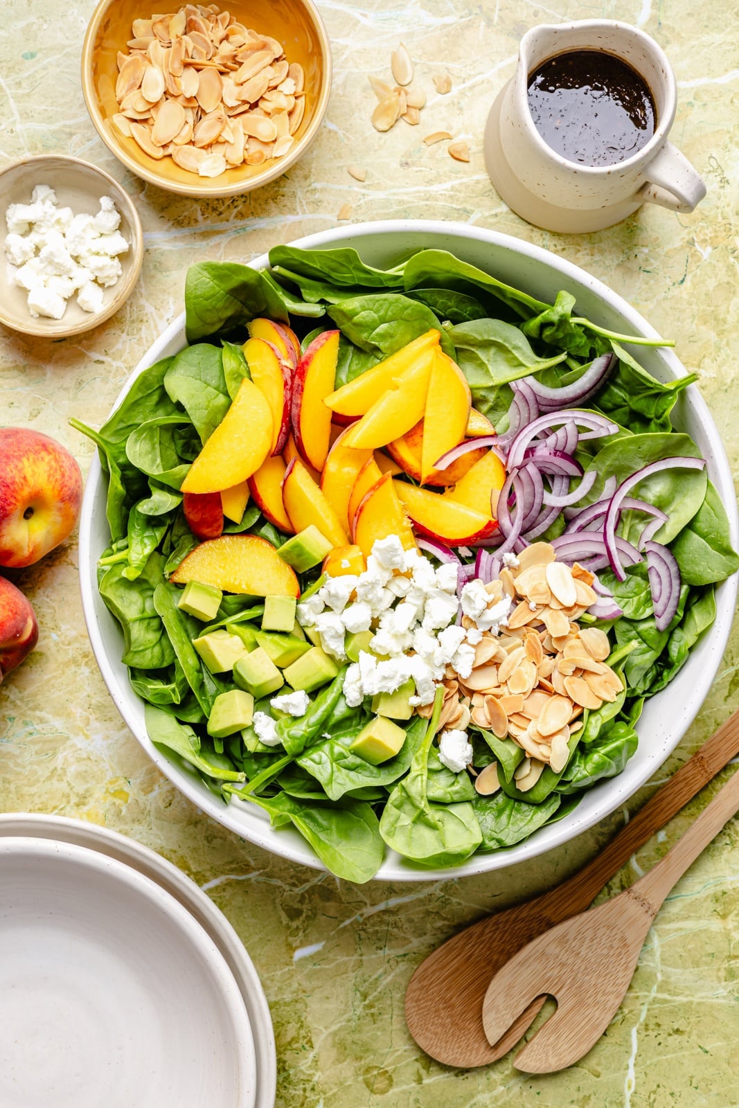 unmixed peach salad with spinach and avocado in a salad bowl