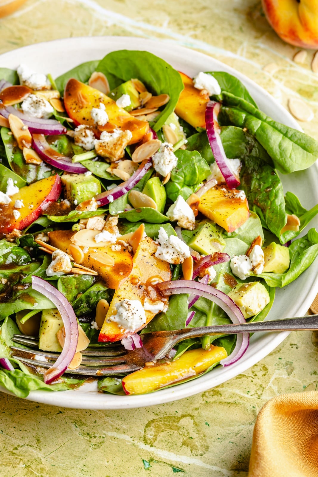 healthy peach spinach salad in a bowl