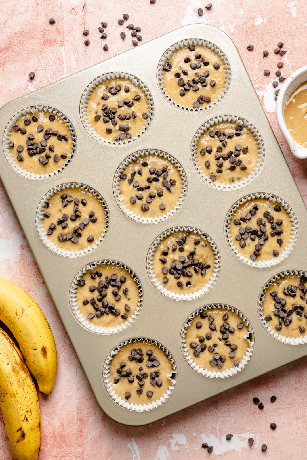 Healthy peanut butter banana muffins packed with protein and peanut butter flavor. These gluten-free peanut butter banana muffins are naturally sweetened with pure maple syrup, dairy-free, and a great on-the-go healthy breakfast or snack. Try them with mini chocolate chips! unbaked peanut butter banana muffins in a muffin pan