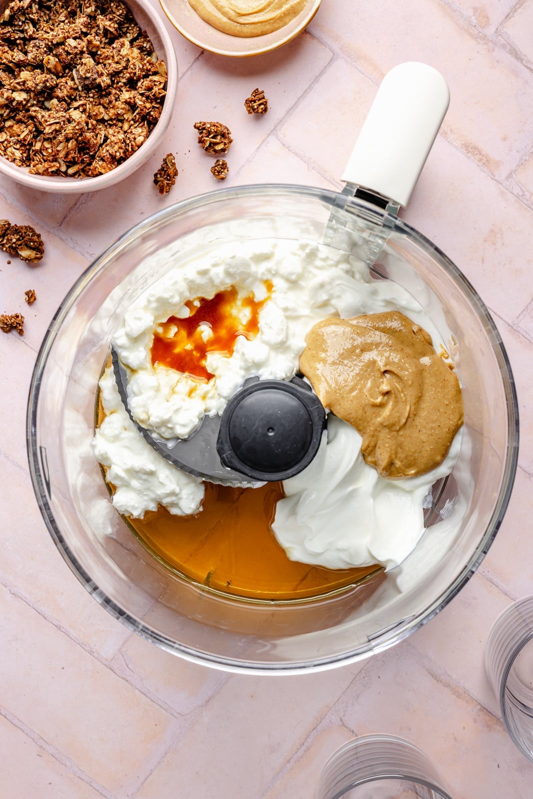 Creamy, high-protein peanut butter cup cheesecake jars layered with crunchy chocolate granola. Top these jars with fresh berries for a healthy breakfast or snack, and add chopped peanut butter cups for a more indulgent dessert! They take just 15 minutes to make and pack over 20g of protein from cottage cheese and greek yogurt. ingredients for high protein chocolate peanut butter cheesecake jars in a food processor