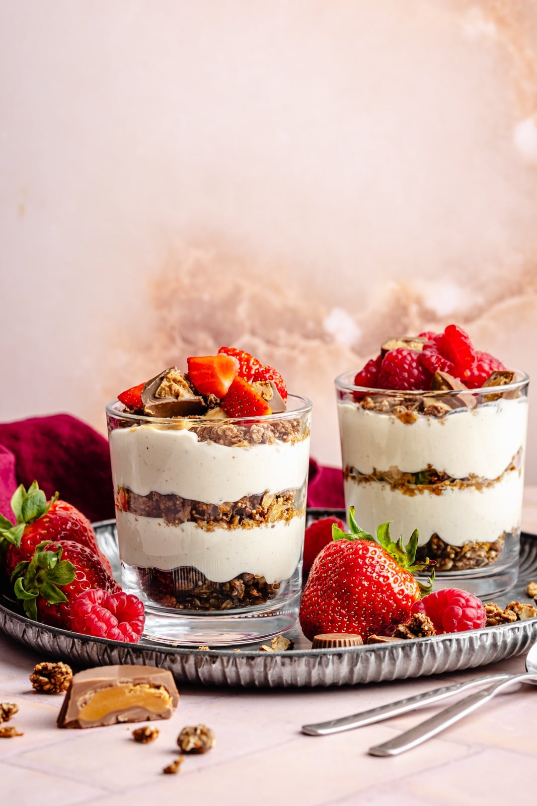 Creamy, high-protein peanut butter cup cheesecake jars layered with crunchy chocolate granola. Top these jars with fresh berries for a healthy breakfast or snack, and add chopped peanut butter cups for a more indulgent dessert! They take just 15 minutes to make and pack over 20g of protein from cottage cheese and greek yogurt. peanut butter cup cheesecake jars topped with berries