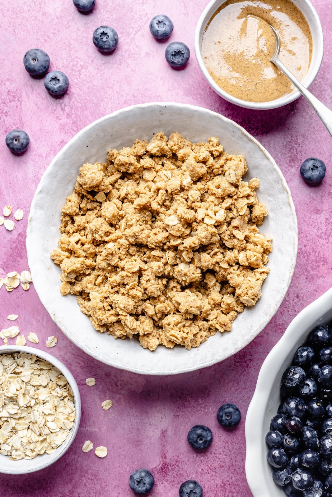 Golden, bubbly blueberry crisp with a perfectly sweet almond butter crumble. This delicious blueberry crisp recipe is easily made gluten-free, dairy-free, and vegan, and makes the perfect summer dessert for sharing. Add a scoop of vanilla ice cream and a drizzle of extra almond butter for good measure! crumble topping for blueberry crisp in a bowl