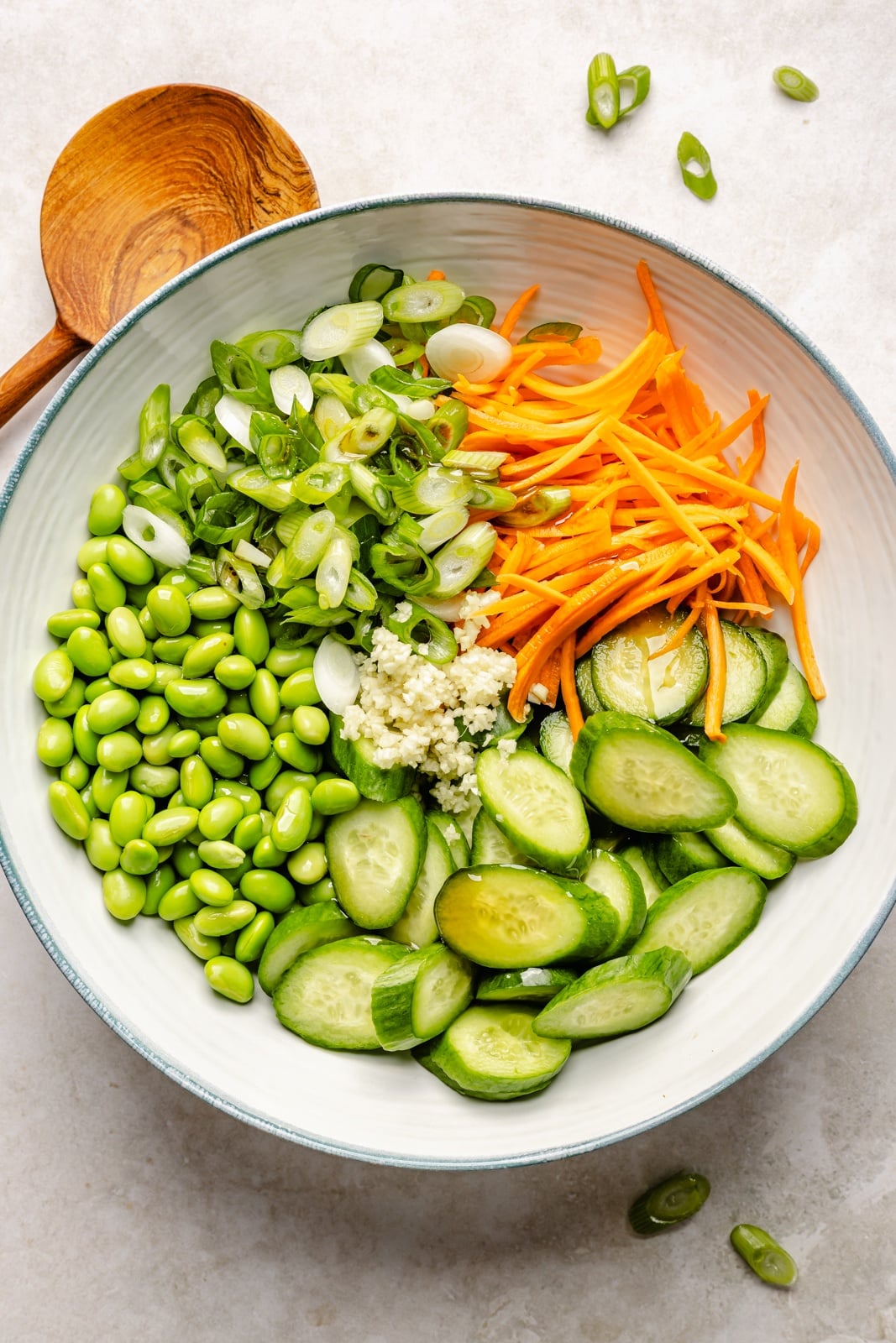 High-protein grilled peanut chicken bowls with edamame cucumber salad and an extra drizzle of flavorful peanut sauce. Assemble these peanut chicken bowls with fluffy rice or quinoa, roasted peanuts, and fresh garnishes for a delicious summer weeknight dinner you'll crave! unmixed edamame salad in a bowl for peanut chicken bowls