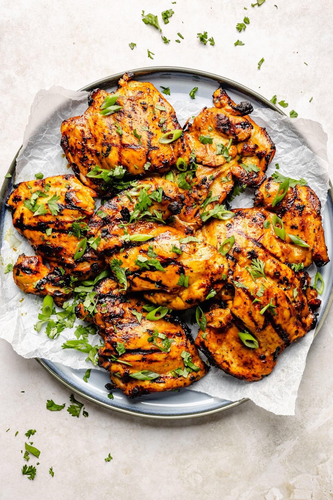 High-protein grilled peanut chicken bowls with edamame cucumber salad and an extra drizzle of flavorful peanut sauce. Assemble these peanut chicken bowls with fluffy rice or quinoa, roasted peanuts, and fresh garnishes for a delicious summer weeknight dinner you'll crave! grilled peanut chicken ona plate