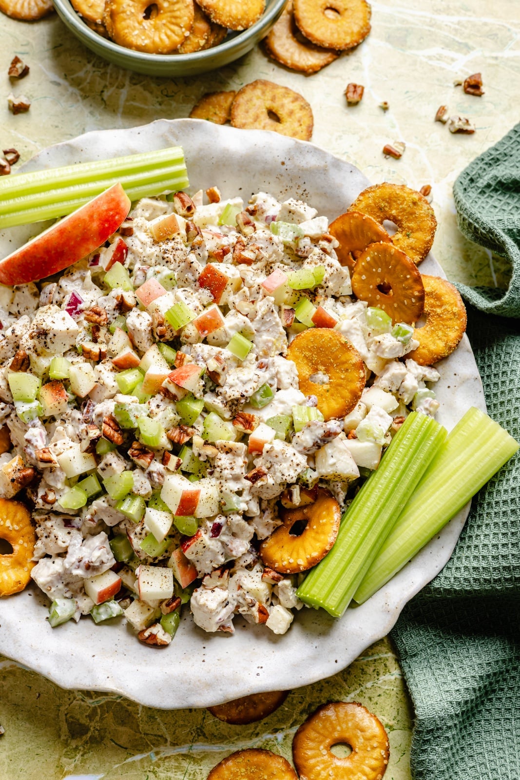 Fresh, high-protein honey mustard chicken salad mixed with a flavorful Greek yogurt-based dressing, juicy honeycrisp apples, and plenty of crunch from celery and nuts. Scoop it with crackers or enjoy it as a sandwich or wrap for the perfect no cook lunch that's ready in 15 minutes! honey mustard chicken salad with apples in a bowl with pretzels and celery