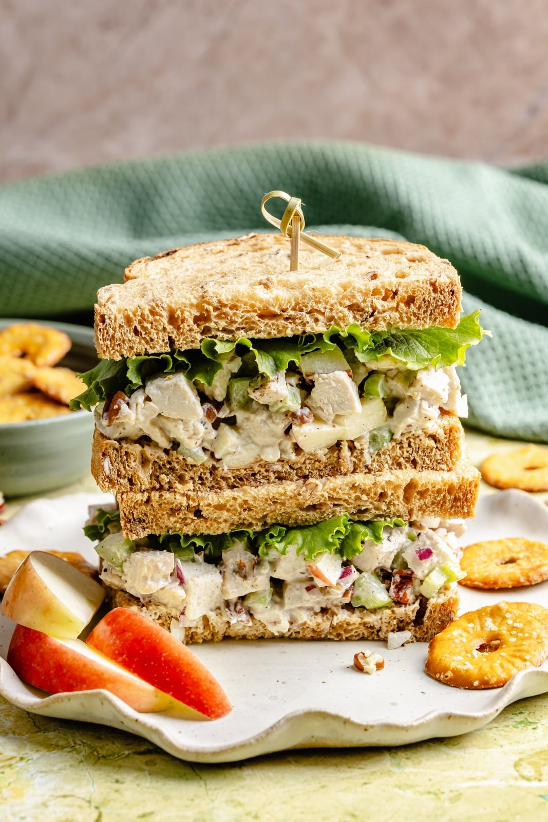 Fresh, high-protein honey mustard chicken salad mixed with a flavorful Greek yogurt-based dressing, juicy honeycrisp apples, and plenty of crunch from celery and nuts. Scoop it with crackers or enjoy it as a sandwich or wrap for the perfect no cook lunch that's ready in 15 minutes! honey mustard chicken salad sandwich in a stack on a plate