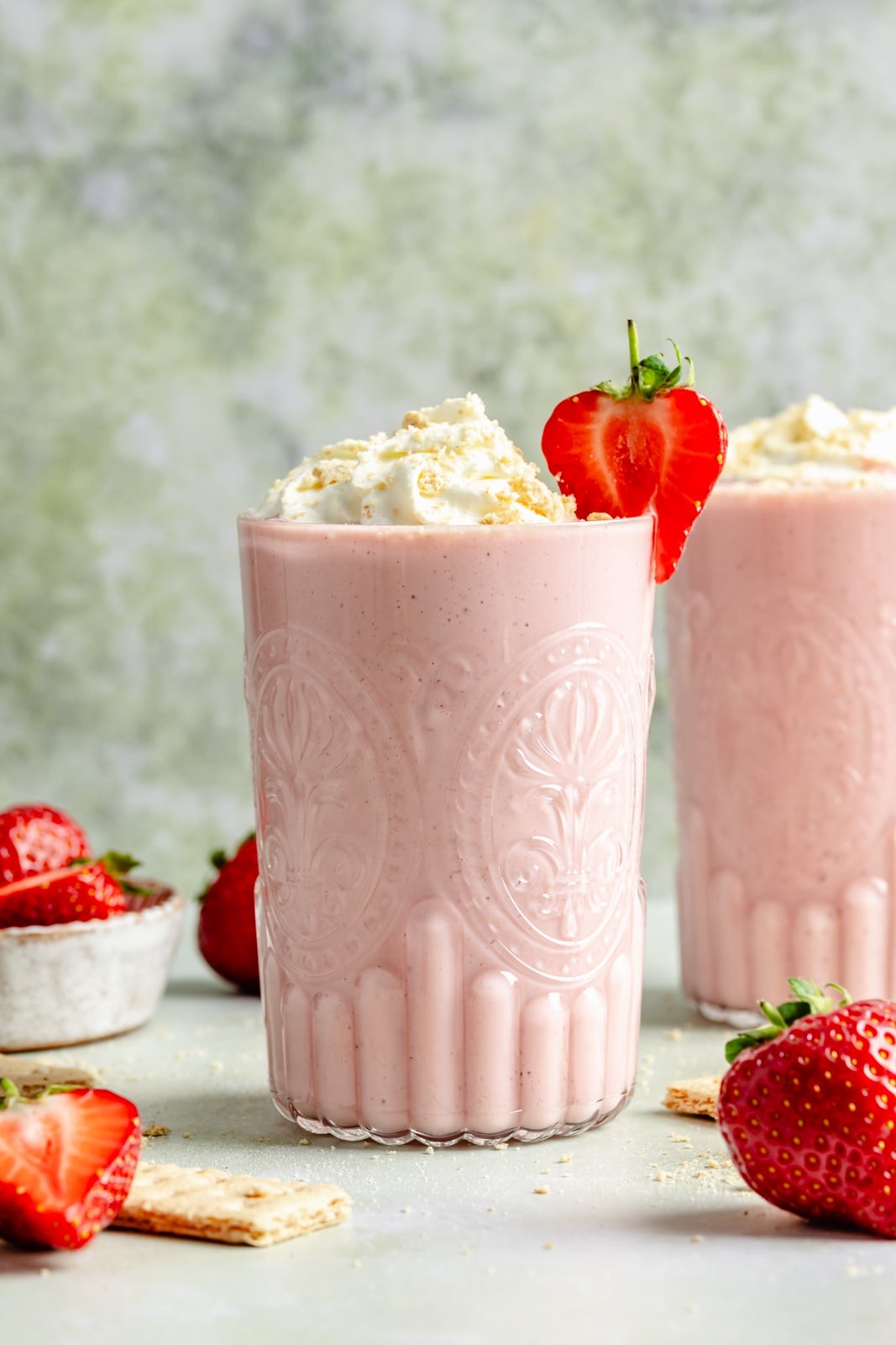 Sweet and tangy strawberry cheesecake smoothie packed with fiber and over 15g of protein from cottage cheese! This easy smoothie is made with just 6 simple ingredients for the perfect breakfast or snack that seriously tastes like dessert. easy strawberry cheesecake smoothie in two glasses