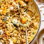 brown butter sage orzo with butternut squash and sausage in a pan with a spoon