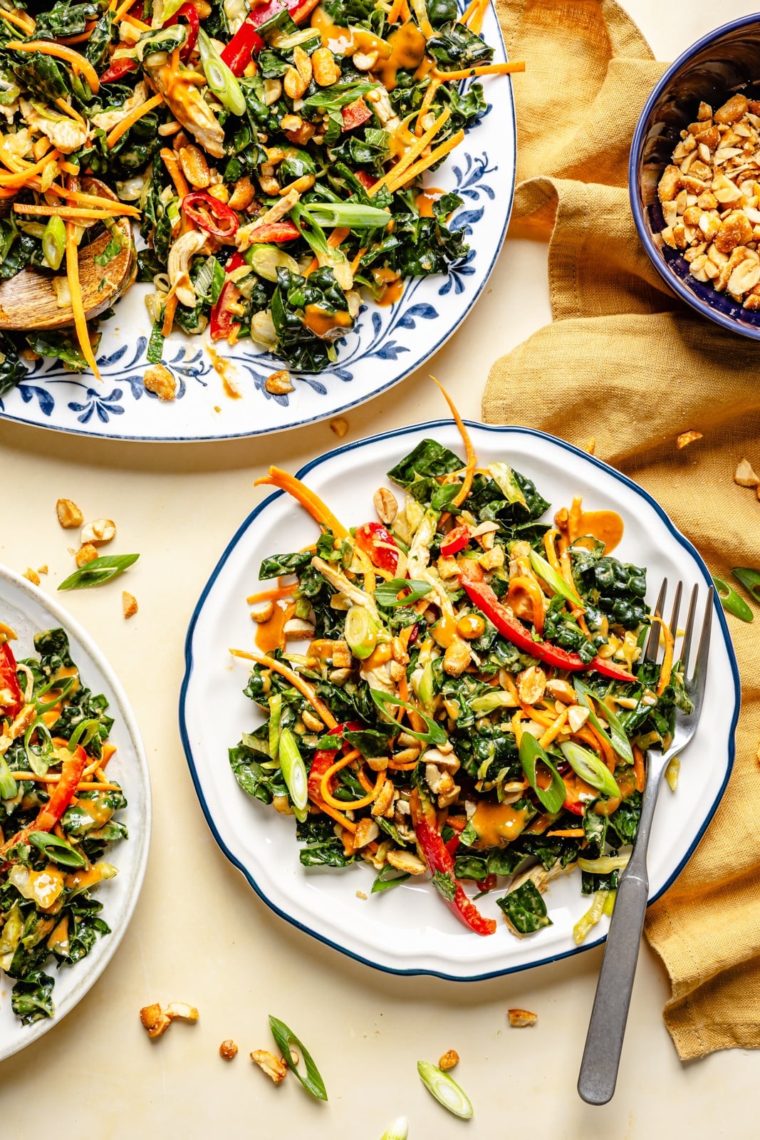 The ultimate crunchy peanut kale salad packed with a rainbow of vegetables and herbs, tossed in a dreamy, creamy ginger peanut dressing. This beautiful kale salad stays good in the fridge for days, making it the perfect high-fiber, protein-packed meal prep lunch! Enjoy as is or add an extra boost of protein for a heartier meal. peanut kale salad on two plates