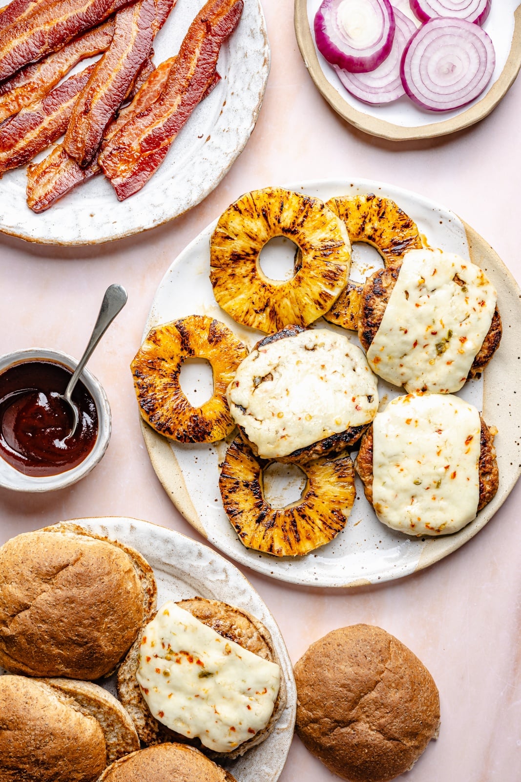 Flavorful, juicy BBQ bacon turkey burgers with a Hawaiian-inspired twist from a slice of sweet grilled pineapple. Use your favorite BBQ sauce, add a kick of heat from pepper jack cheese, and grill or pan-fry these burgers for the ultimate summer dinner! assembling BBQ bacon turkey burgers with pineapple