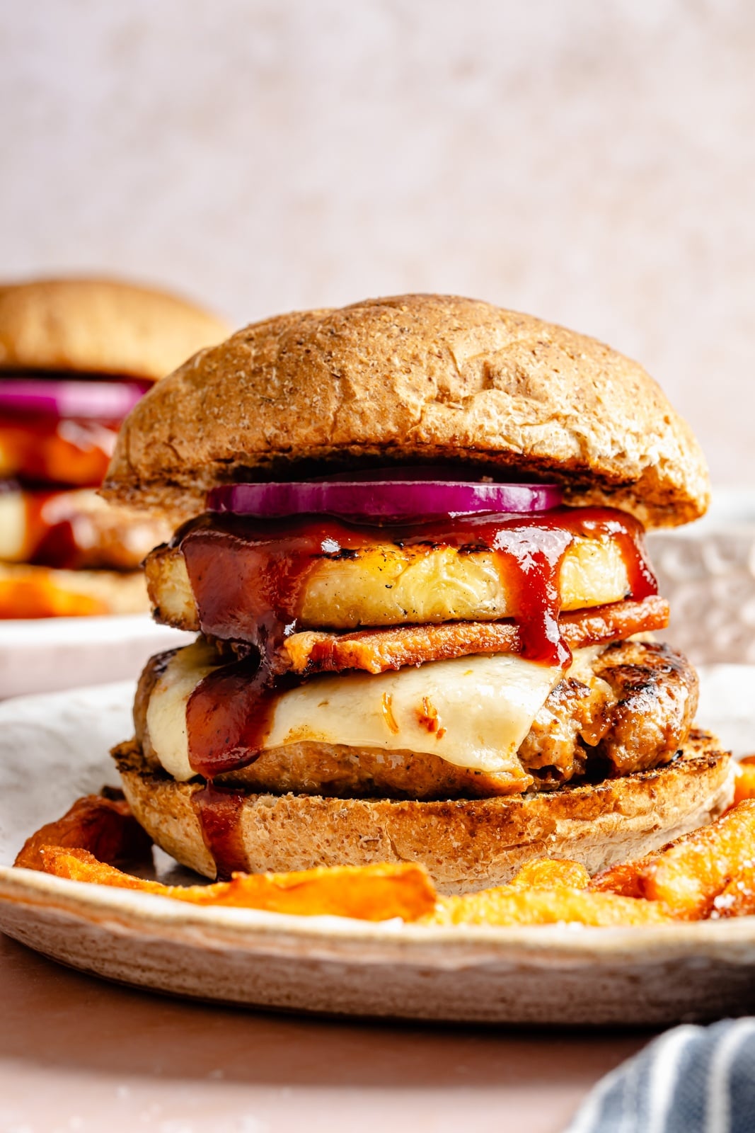 Flavorful, juicy BBQ bacon turkey burgers with a Hawaiian-inspired twist from a slice of sweet grilled pineapple. Use your favorite BBQ sauce, add a kick of heat from pepper jack cheese, and grill or pan-fry these burgers for the ultimate summer dinner! BBQ bacon turkey burger with pineapple on a plate