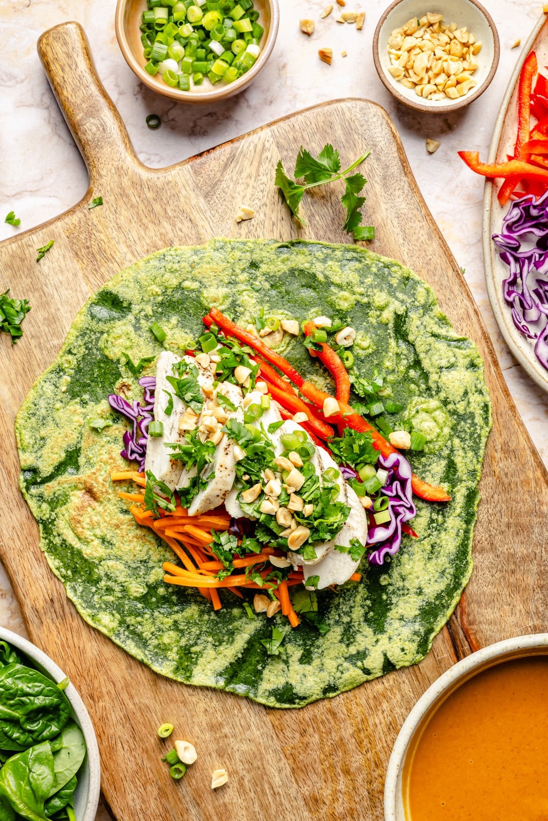 thai peanut chicken wrapped un-rolled on a cutting board