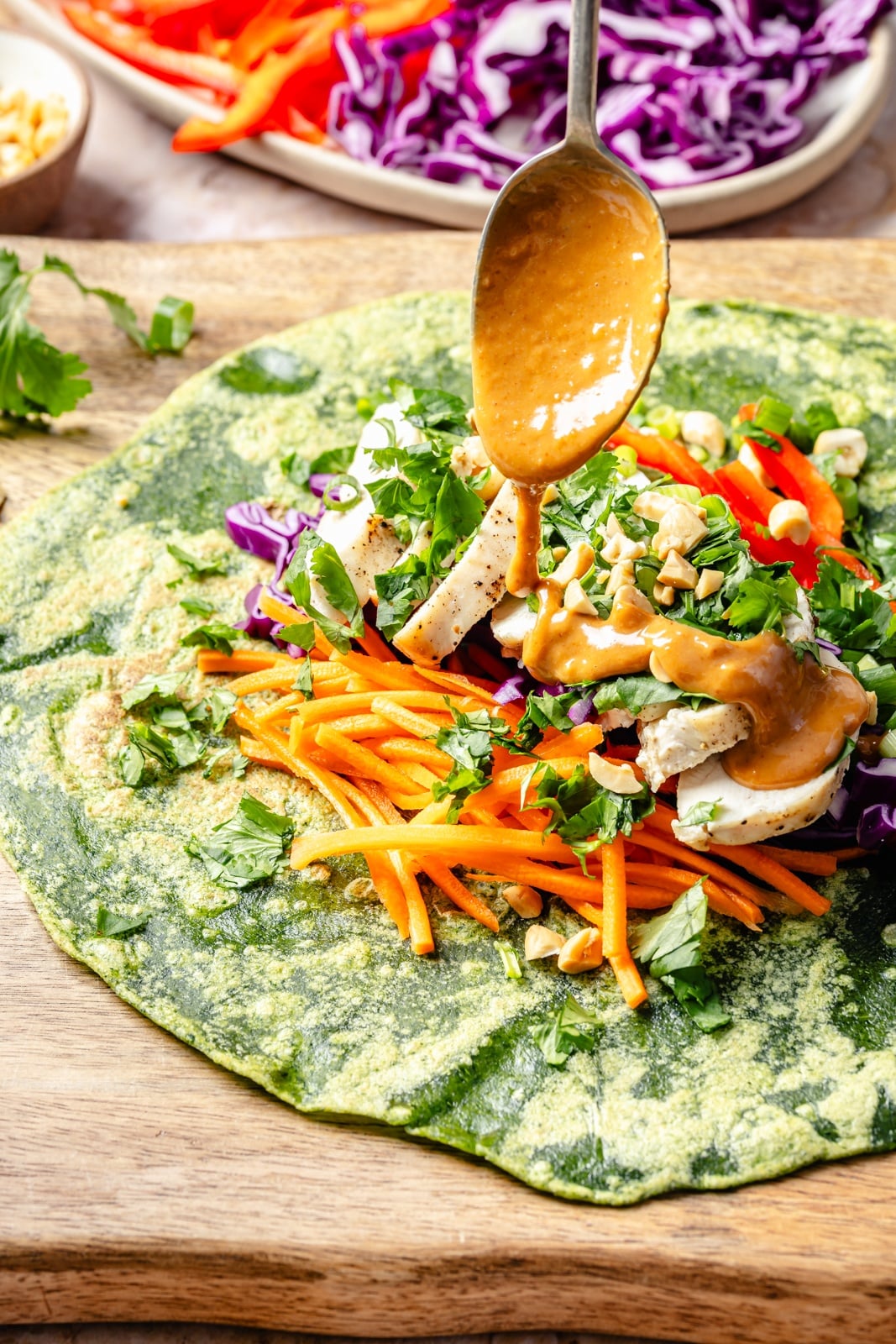 drizzling a thai chicken wrap with peanut dressing