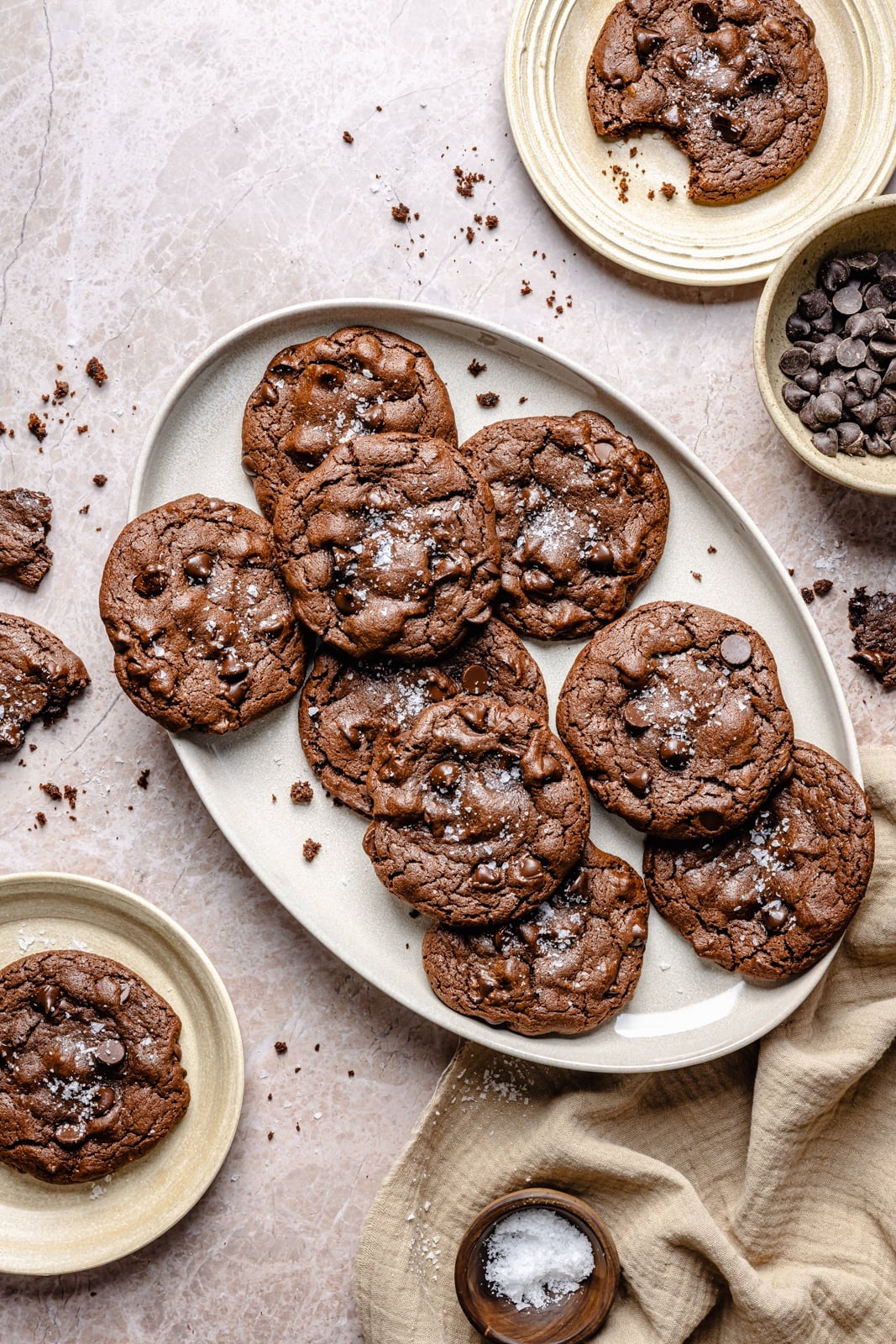 Fudgy double chocolate olive oil cookies with perfectly crisp edges and chewy centers. These incredible cookies take just 10 minutes to mix and 10 to bake, so you can have the ultimate chocolate lover's dessert in no time! Easily make them gluten-free, and add a sprinkle of sea salt for a sweet-salty combo. chocolate olive oil cookies on a platter and plates