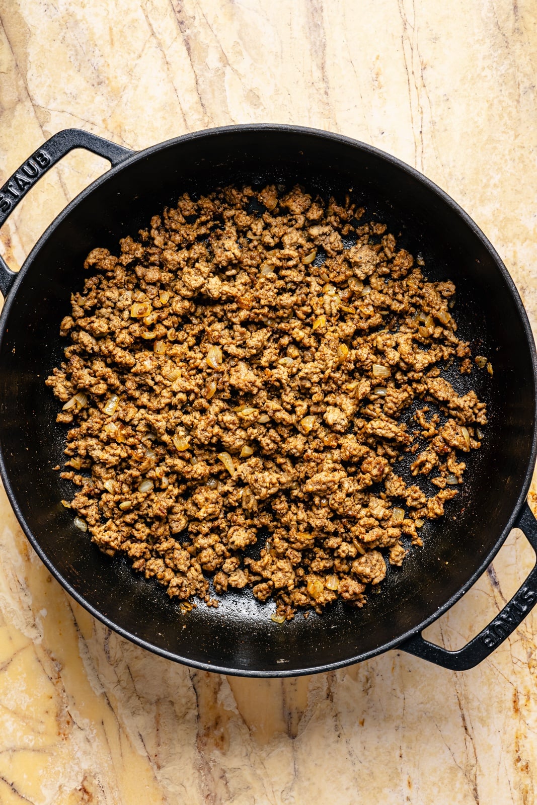 cooking beef in a skillet for a beef and pumpkin enchilada skillet