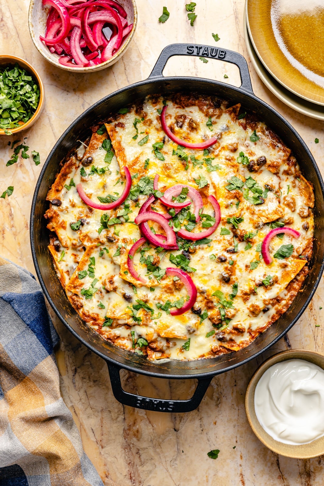 beef and pumpkin enchilada skillet topped with pickled red onion