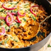 pumpkin and beef enchilada skillet in a pan with a metal spoon