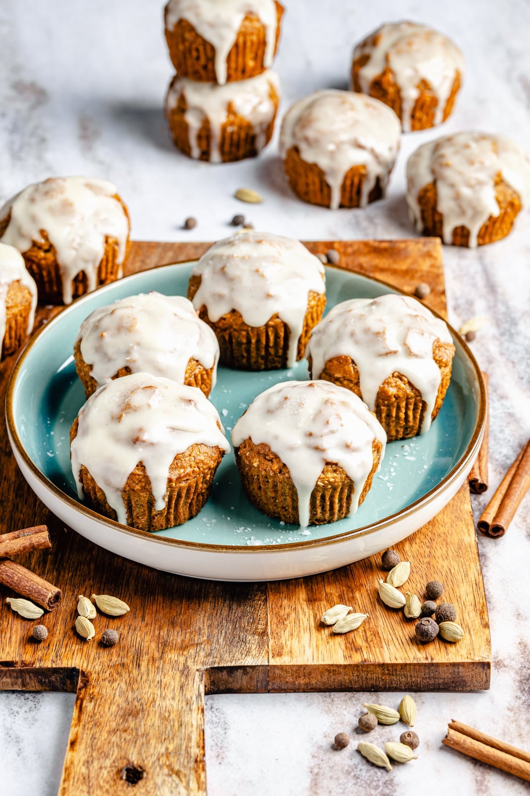 Fluffy butternut squash muffins infused with homemade chai spices, then topped with a simple salted honey glaze that truly takes these to the next level. These fall-inspired, freezer-friendly butternut squash muffins are easy to make and have hints of caramel flavor thanks to a touch of brown butter. Perfect with a cup of coffee! butternut squash muffins with honey glaze on a plate and cutting board